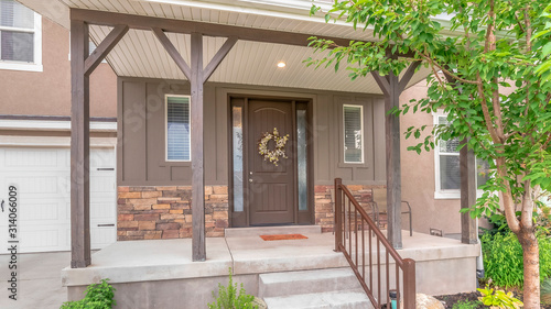 Pano frame Home with stairs leading to porch and door flanked with sidelights and windows