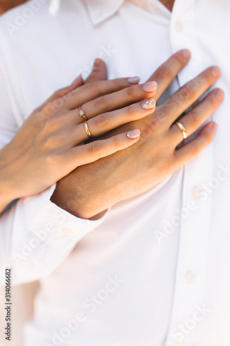 Hands with couple rings on their wedding day on an island
