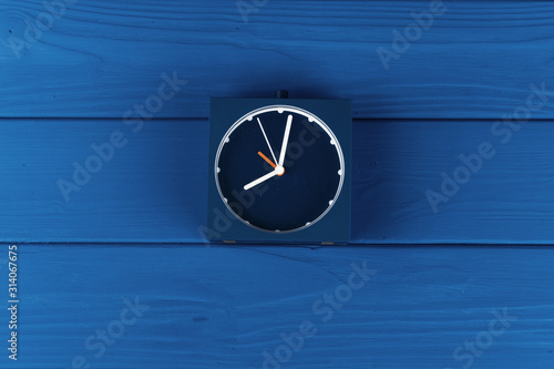 Top view of alarm clock on classic blue background