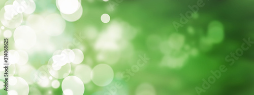 Green abstract background with blurred bokeh circles. The atmosphere of spring and air magic.