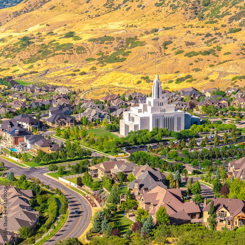 Square frame Salt Lake City Utah suburbs with a white temple towering over houses and roads