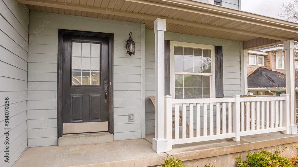 Pano Exterior of home with glass panels on front door and stairs going to the porch