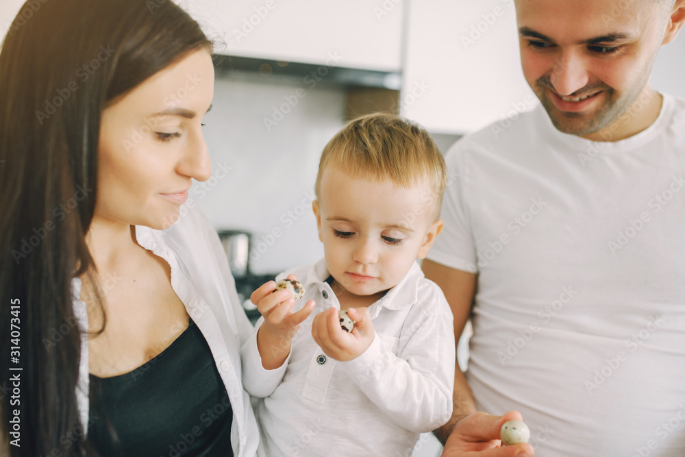 Family in a kitchen. Beautiful mother with little son. Father in a white t-shirt. Family in a kitchen. Beautiful mother with little son. Father in a white t-shirt.