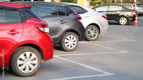 Closeup of rear, back side of red car with  other cars parking in outdoor parking area in sunny day.  © Amphon