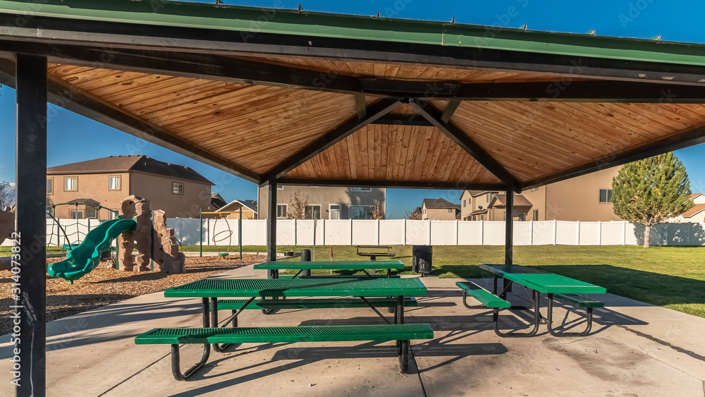 Panorama Picnic tables under a wooden roof in a park