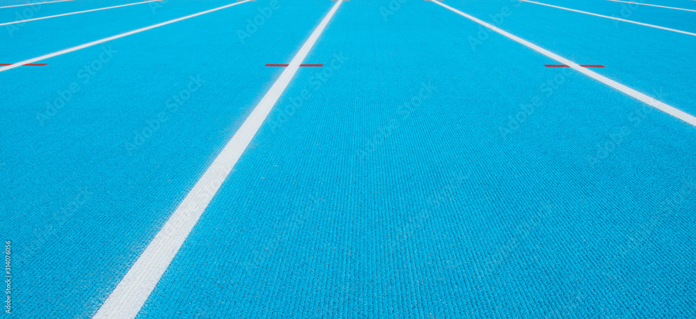 Blue running track with white lines and red mark in sport stadium. Top view