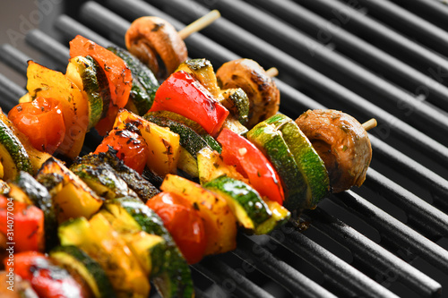 Barbecue vegetable skewers on a dark background from mushrooms, tomato, zucchini, pepper, buttery, bright, vegetarian. Dark background. Horizontally. photo