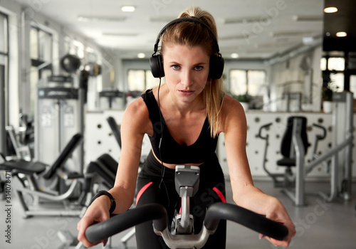 Sporty woman working out with exercise bike