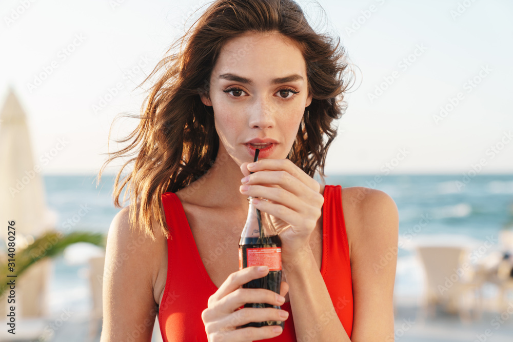 Photo of beautiful nice woman drinking soda and looking at camera foto de  Stock | Adobe Stock
