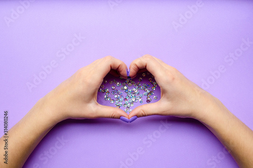 Girl holding hands with heart. Stylish trendy photo