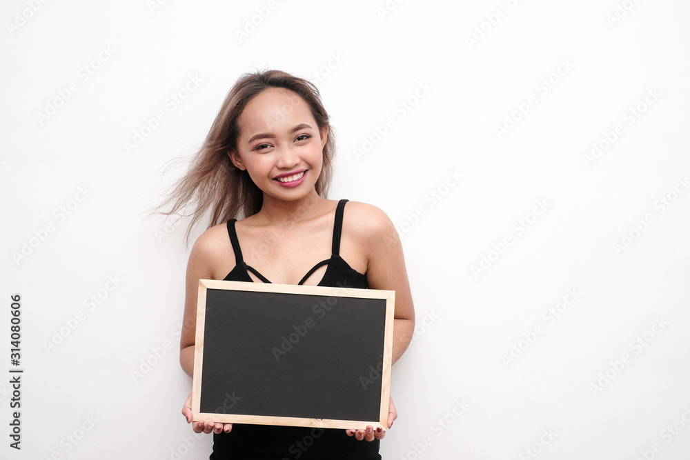 Young girl holding blank black board or sign. Young girl holding blank black board or sign.