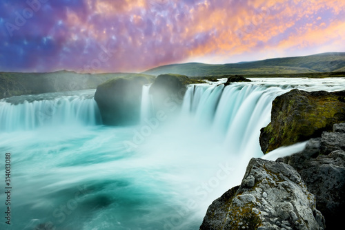 Cascades of waterfalls dropping down from the cliffs. Long exposure. tslandtya. A beautiful waterfall  frozen motion of water streams on a long exposure. The most visited waterfall in Iceland. Waterfa