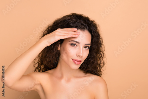 Close-up portrait of her she nice-looking attractive sweet winsome well-groomed perfect shine wavy-haired girl showing forehead laser cosmetology effective advert isolated on beige pastel background