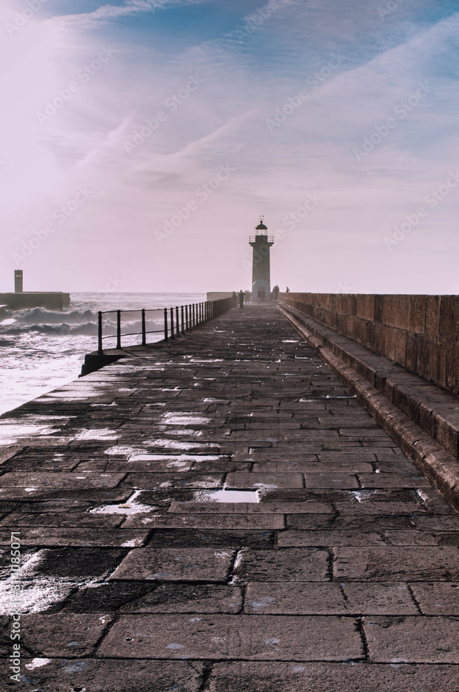 Obraz premium The pier to the Sunset Lighthouse. Lighthouse as a Ladmark. Foz do Douro. Porto. PortugalLighthouse as a Landmark
