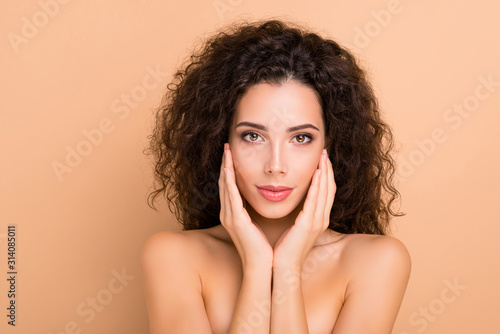 Close up photo beautiful amazing she her model smearing touch facial skin healthy curls hairdo ideal appearance plump allure tempting big lips wear no clothes nude isolated beige pastel background