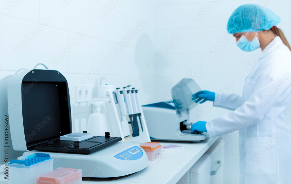Young female lab assistant making copy of analysis results Young female lab assistant making copy of analysis results
