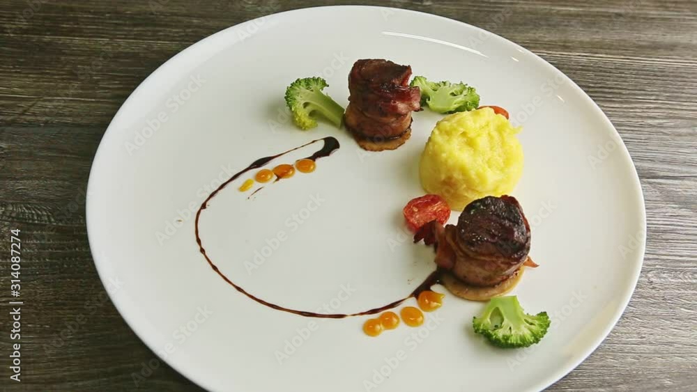 slow zoom in at meat pieces roasted in bacon with puree and broccoli slow zoom in at meat pieces roasted in bacon with puree and broccoli
