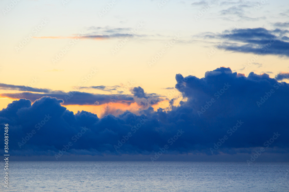 Fototapeta premium Bright cumulus clouds against the blue sky. Sunset sky Natural background. seascape