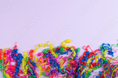 Festive party border or frame of colorful spiral streamers on pink background