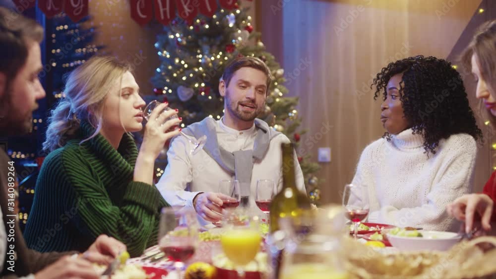 Handsome joyful man making a wine toast with friends sitting at rich holiday dinner table celebrating reunion time together on Christmas. Happy holidays. Handsome joyful man making a wine toast with friends sitting at rich holiday dinner table celebrating reunion time together on Christmas. Happy holidays.