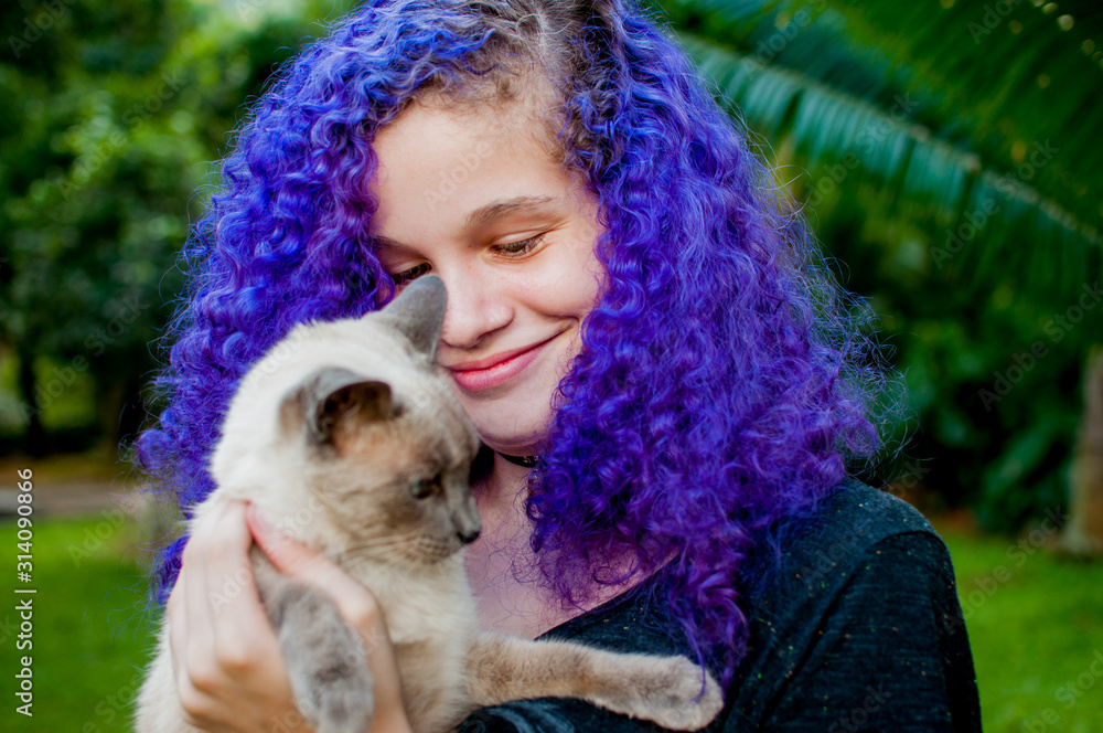 Young colored haired woman holding a cat Young colored haired woman holding a cat