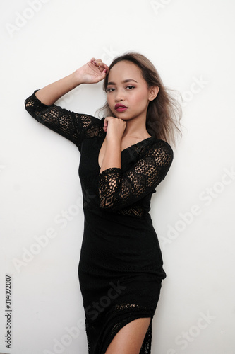 Young sexy girl wearing a black long lace dress, shot on isolated white background.