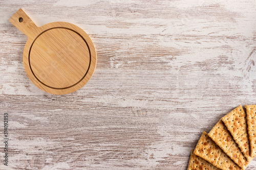 Tabla de madera con avellanas y bellotas, galletas tostadas con queso photo