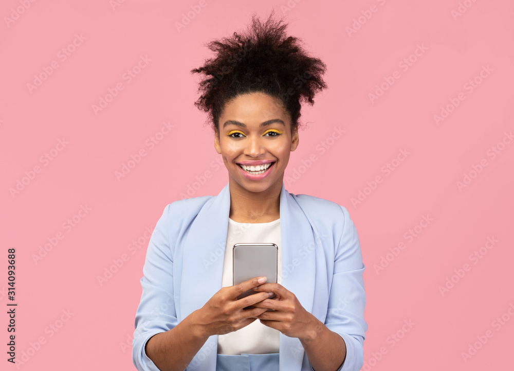 Smiling afro girl using cell phone looking at camera Smiling afro girl using cell phone looking at camera