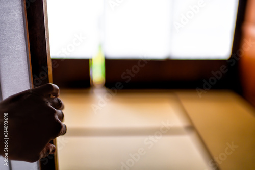 фотографія Traditional japanese home or ryokan with macro closeup of hand touching opening