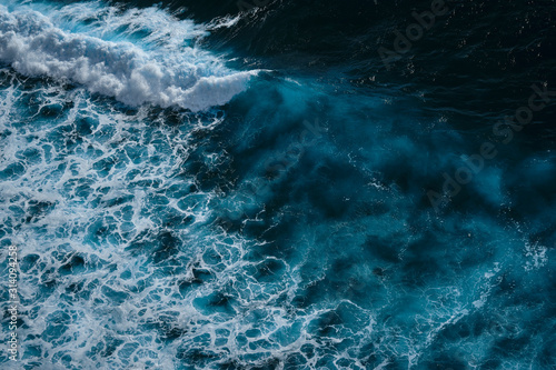 Aerial view to seething waves with foam. Waves of the sea meet each other during high tide and low tide. Dramatic colors photo. Image with place for text.