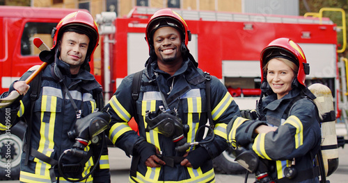Fototapeta Portrait of group firefighters standing near fire truck
