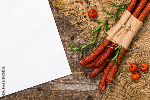 Kabanos or Cabanossi Thin Dry Smoked Polish Sausage on Wooden Background with Space for Text. Selective focus. photo