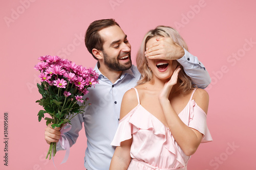 Fotografia Cheerful young couple two guy girl in party outfit celebrating isolated on pastel pink background