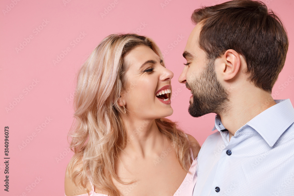 Close up of laughing young couple two guy girl in party outfit posing isolated on pastel pink wall background. Valentine's Day Women's Day birthday holiday concept. Doing selfie shot on mobile phone. Close up of laughing young couple two guy girl in party outfit posing isolated on pastel pink wall background. Valentine's Day Women's Day birthday holiday concept. Doing selfie shot on mobile phone.