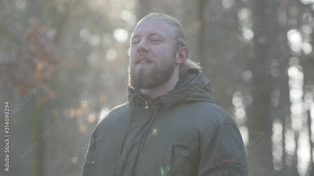 Portrait of happy Caucasian man standing in autumn forest and smiling. Adult male tourist enjoying his travel outdoors. Leisure, lifestyle, happiness. Portrait of happy Caucasian man standing in autumn forest and smiling. Adult male tourist enjoying his travel outdoors. Leisure, lifestyle, happiness.
