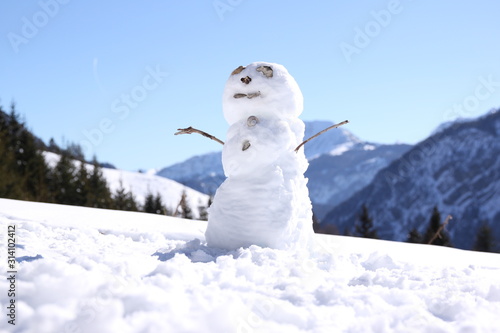 Snowman in front of wintry mountains