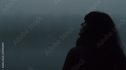 Woman Looking Around in the Cold Misty Lake