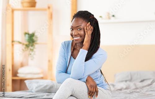 Joyful Black Woman Posing Sitting In Comfortable Bed Indoor