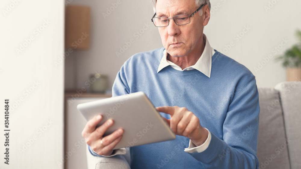 Senior Gentleman Using Tablet Sitting On Sofa At Home, Panorama Senior Gentleman Using Tablet Sitting On Sofa At Home, Panorama