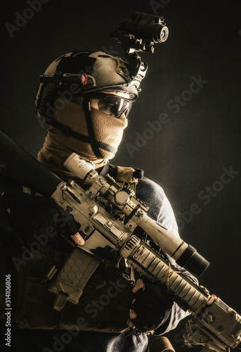 Shoulder portrait of army elite troops sniper  anti-terrorist tactical team marksman wearing helmet with thermal imager  hiding face behind mask  armed rifle with optical scope  studio shoot on black