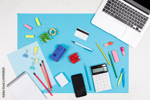 Calculator, laptop, mobile phone, stationery isolated on blue and white background