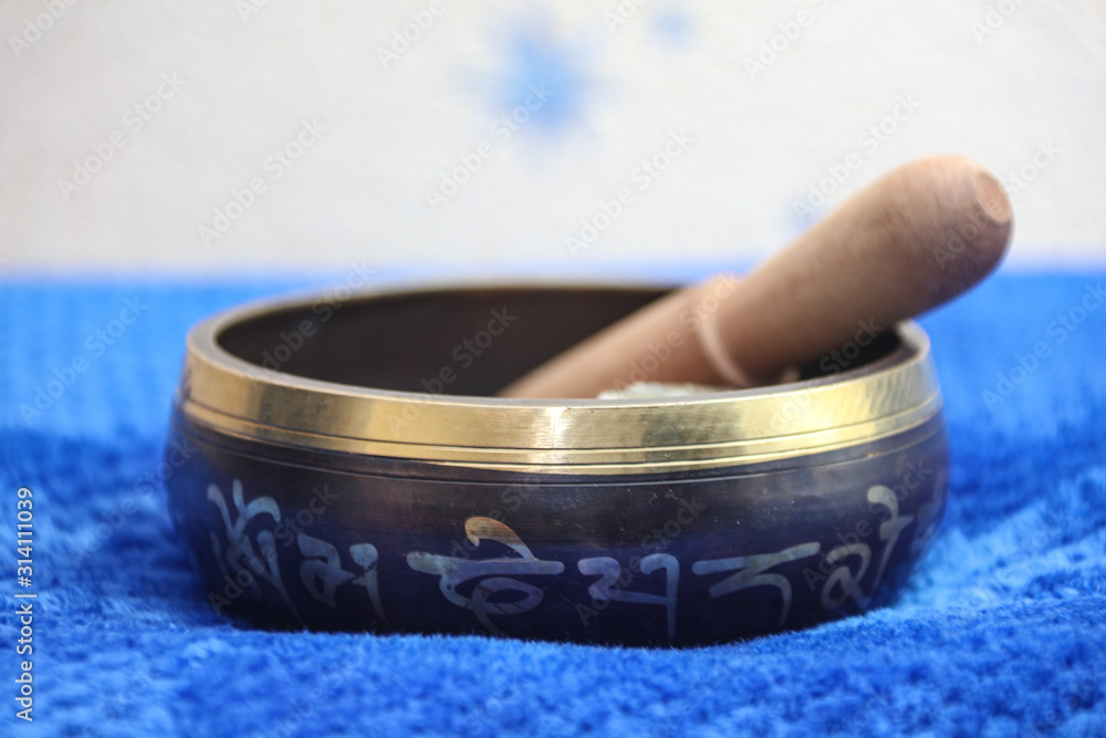 Tibetan singing bowl with the wooden bat. Chinese symbols translation: jewel in the lotus