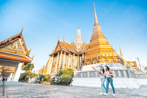  women friends enjoy sightseeing while travel in temple of the emerald buddha in Thailand