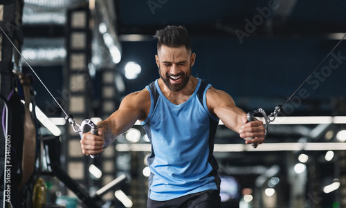 фотографія Bodybuilder training with block exerciser at gym