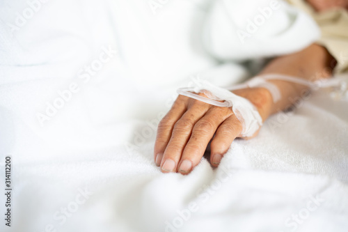 hand of the patient who is receiving the saline solution in the room of the patient in the hospital who is suffering from diarrhea.