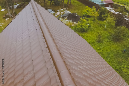 Brown metal tile on the roof of the house. Corrugated metal roof photo