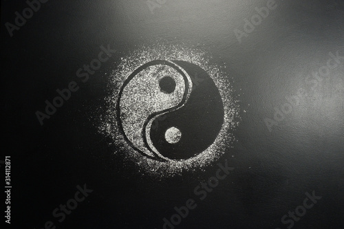 Drawing flour on a black board. Yin Yang photo