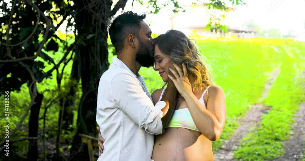 Pregnant mom's happiness when receiving a passionate kiss on her husband's forehead. Fix camera