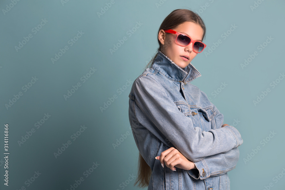 Plakat portrait of a beautiful young woman in sunglasses on a blue background