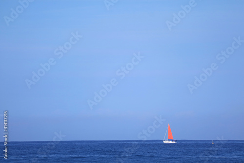 Red Sail Yacht in Sailing on the Deep Blue Ocean 